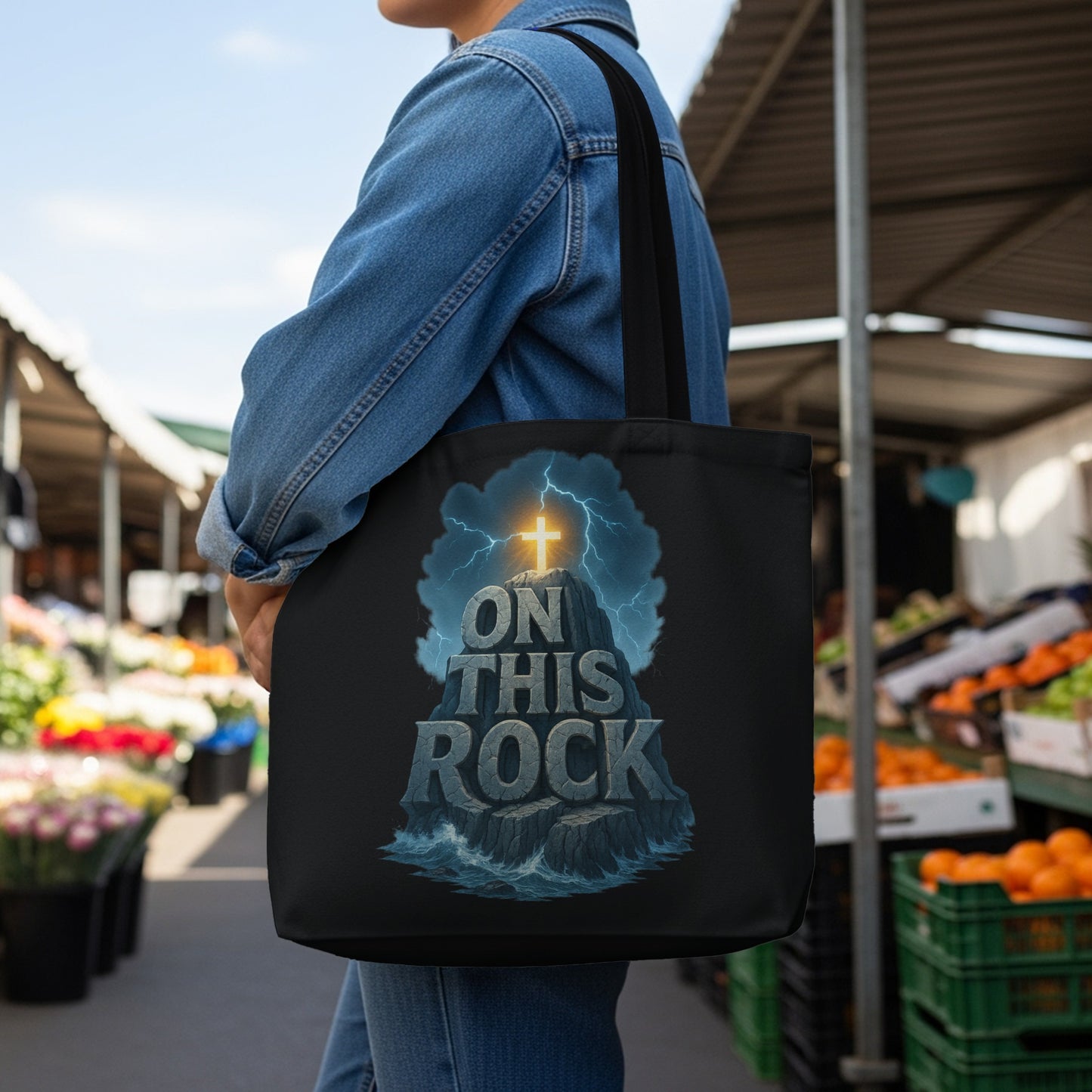 Black tote bag with "ON THIS ROCK" text and a cross on a stormy rock.