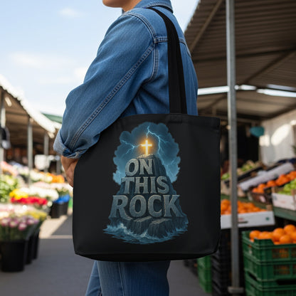 Black tote bag with "ON THIS ROCK" text and a cross on a stormy rock.