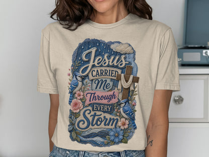 Beige t-shirt with "Jesus Carried Me Through Every Storm" denim-inspired graphic.