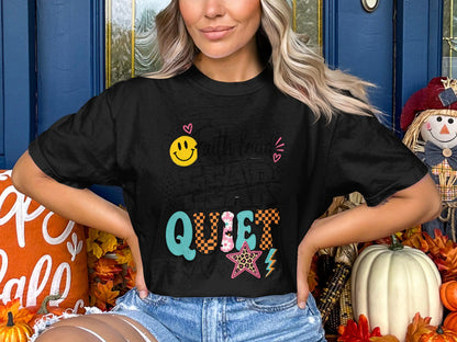 Black t-shirt with "QUIET" text design featuring smiley face and cheetah star.