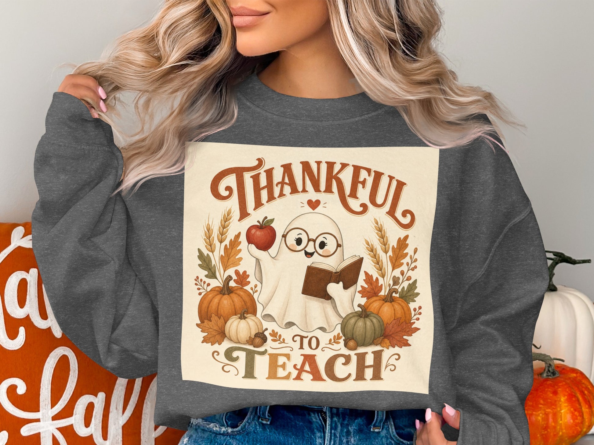 Ghost holding apple and book with text "Thankful to Teach" and pumpkins.