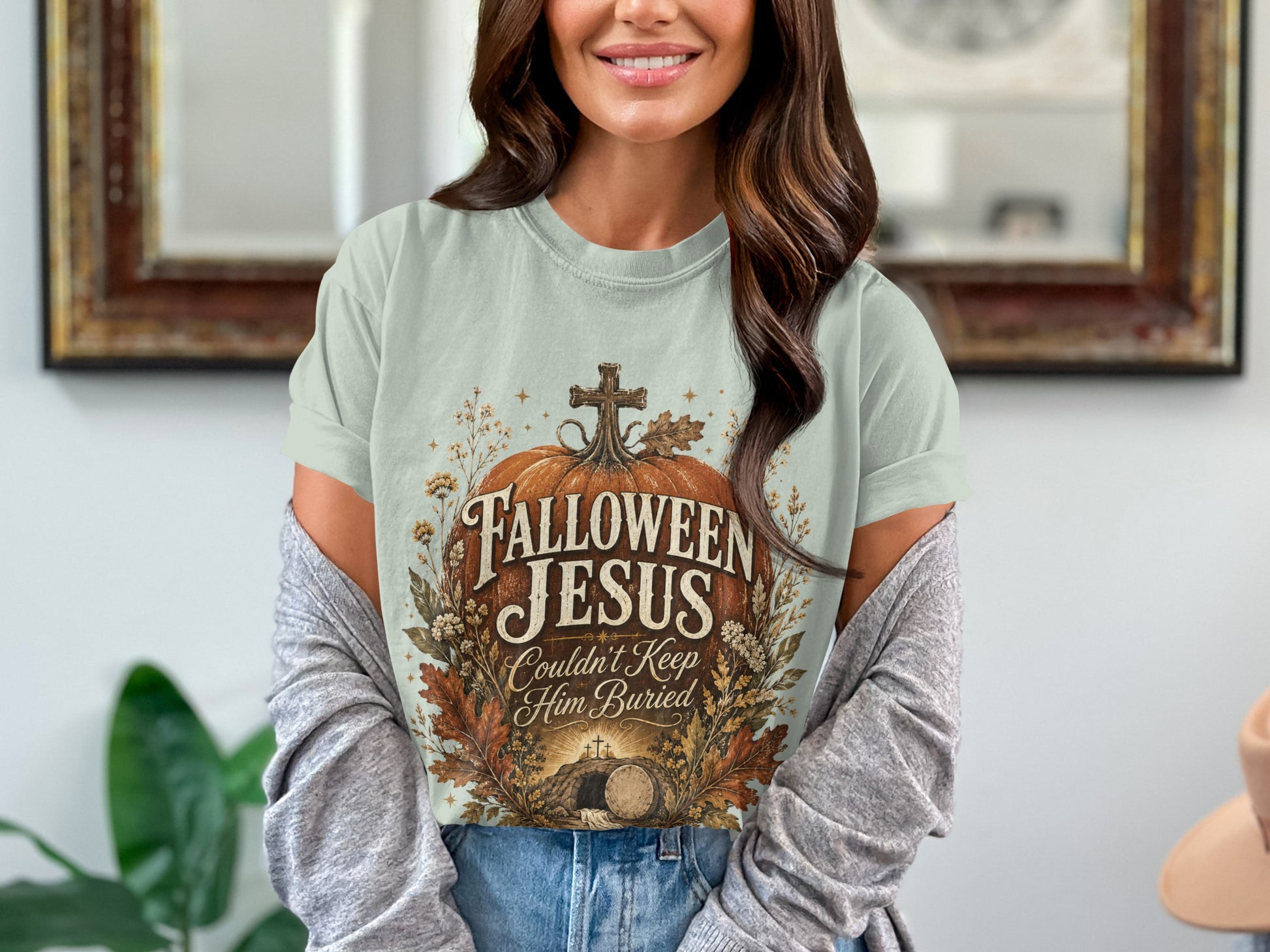 Light blue t-shirt with pumpkin design, "Fallloween Jesus Couldn't Keep Him Buried" text.