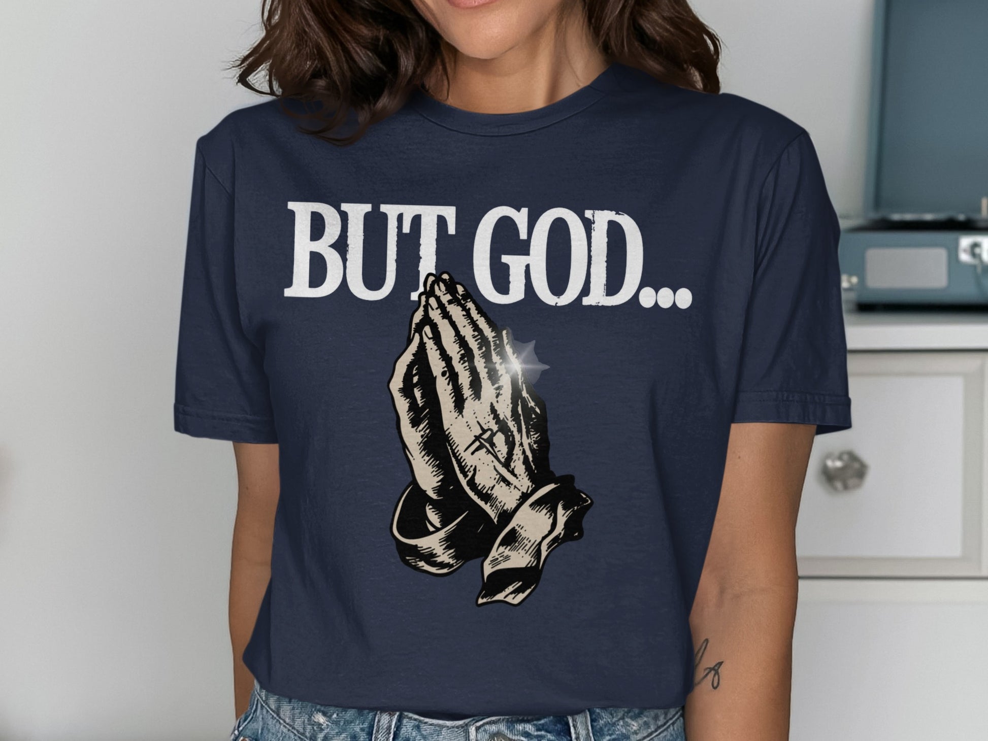 Navy t-shirt with "BUT GOD..." and praying hands graphic.