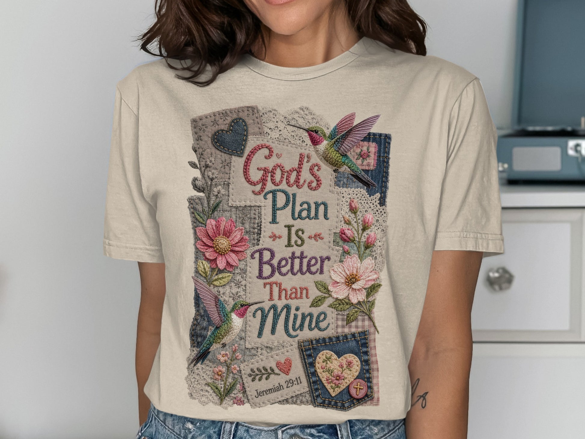 Cream t-shirt with "God's Plan Is Better Than Mine" and floral hummingbird design.