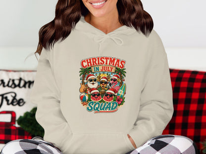 Cream hoodie with "Christmas in July Squad" graphic featuring Santa and summer characters.