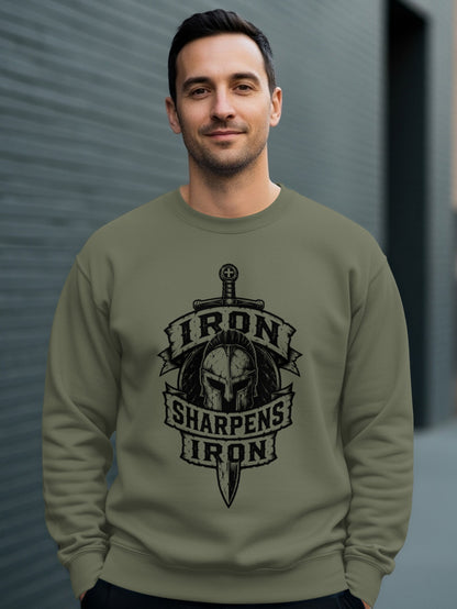 Man wearing olive sweatshirt with "Iron Sharpens Iron" Spartan helmet and sword design.