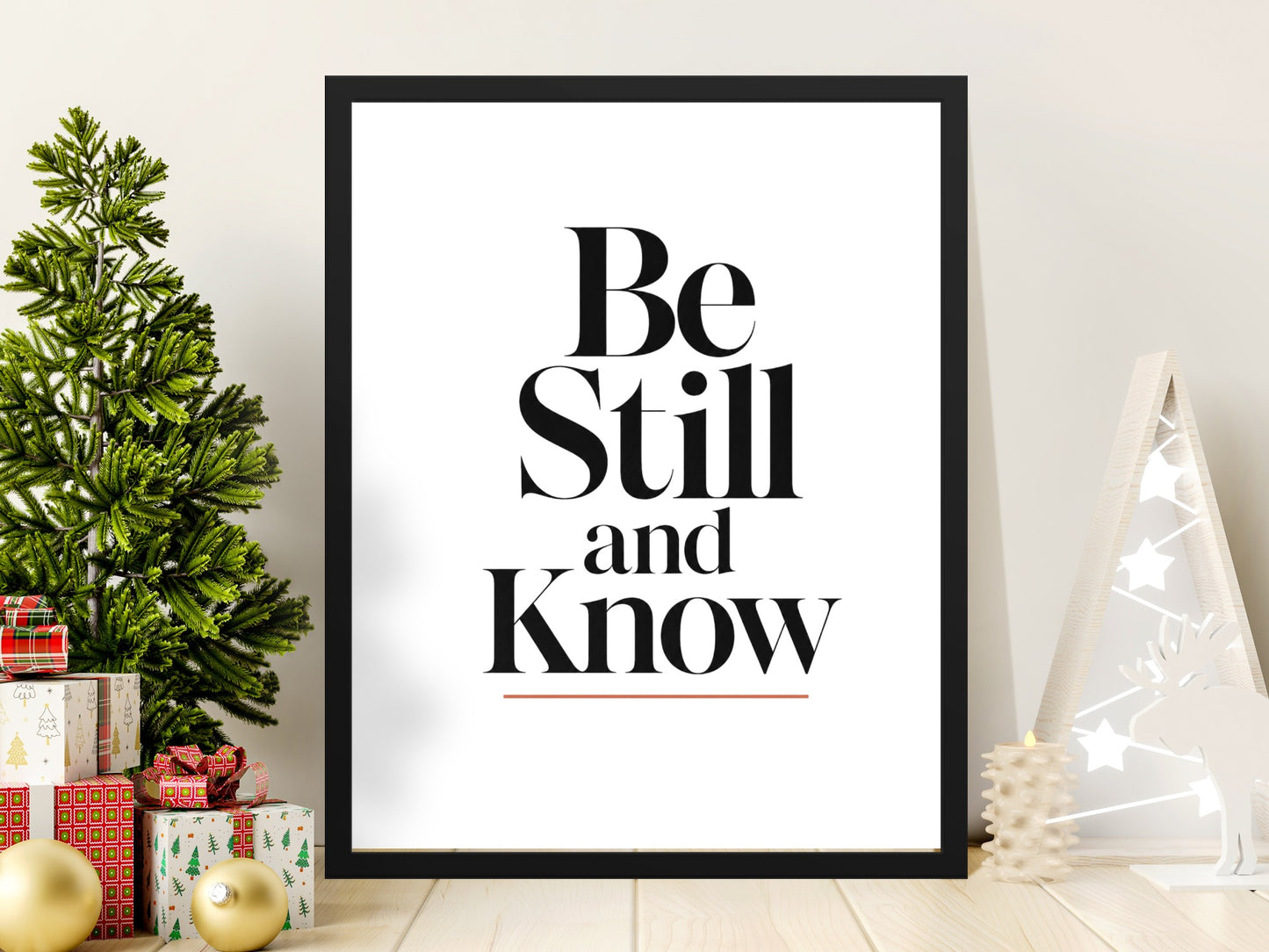 Framed print with text "Be Still and Know" on a festive holiday scene.