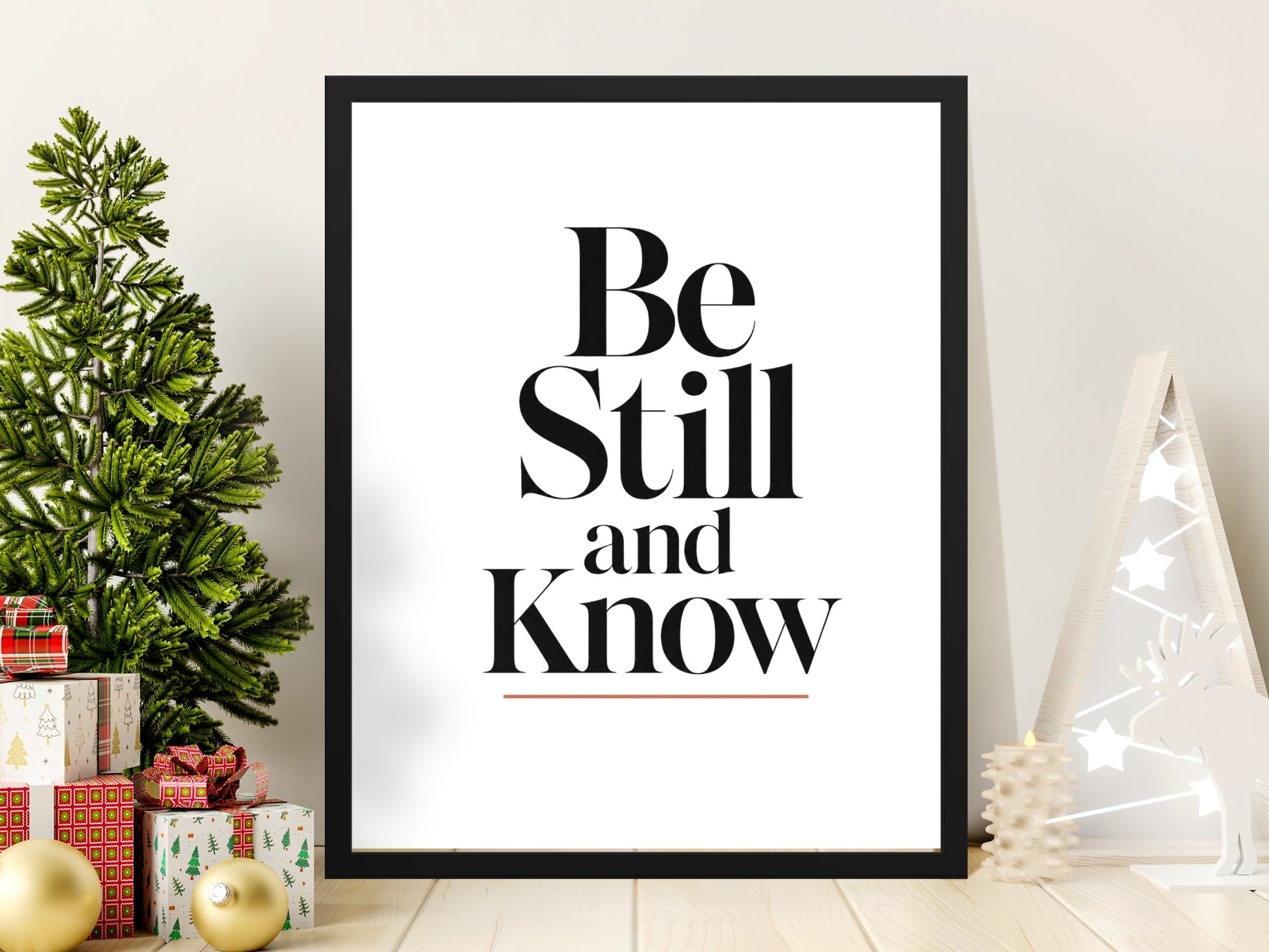 Framed print with text "Be Still and Know" on a festive holiday scene.