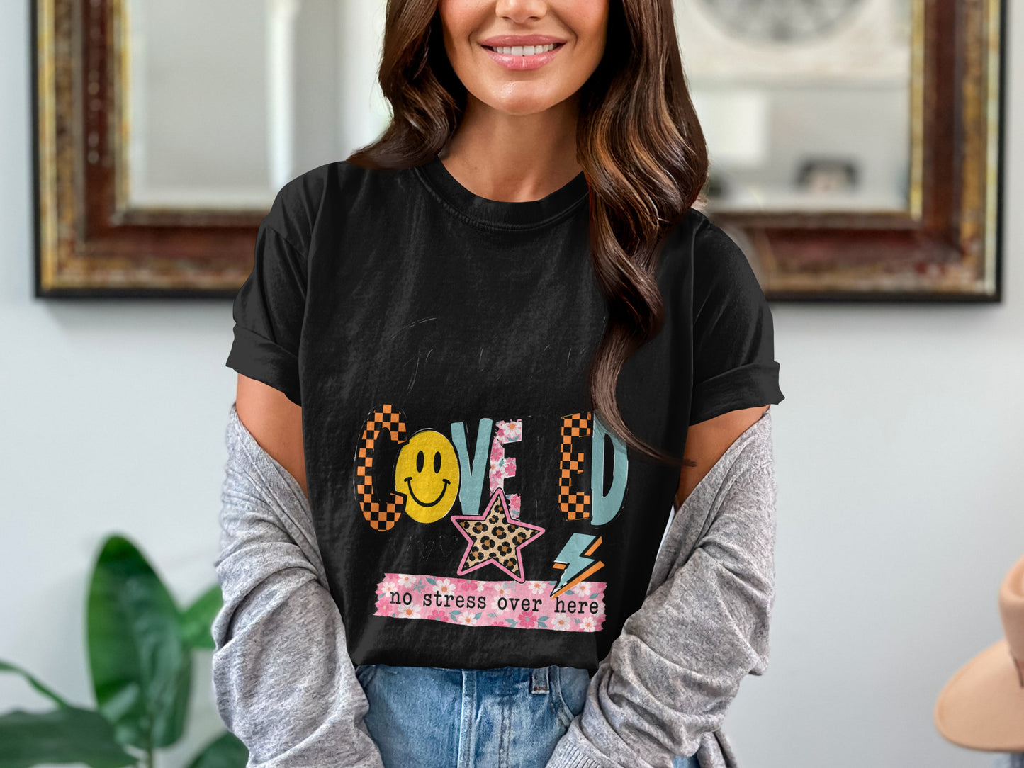 Black t-shirt with "Coved" and "no stress over here" text, smiley, and star designs.