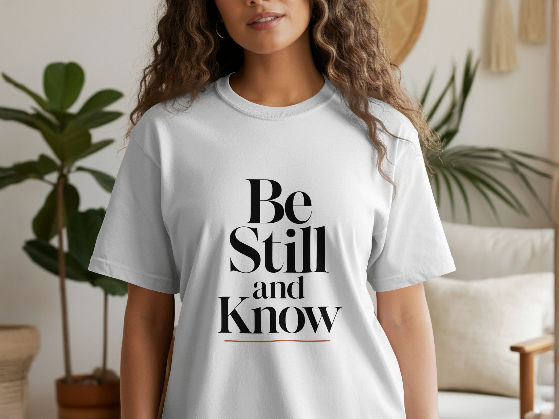 White t-shirt with black text "Be Still and Know"