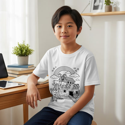 Child in white t-shirt with Noah's Ark design, sitting at a desk.
