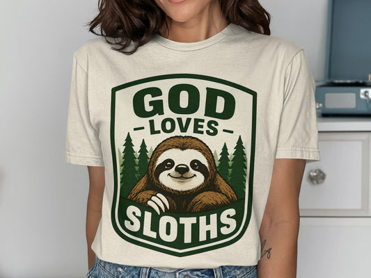 Cream t-shirt featuring a shield logo with a sloth and the text "GOD LOVES SLOTHS".