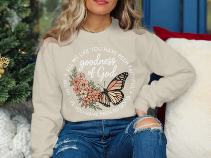 Cream sweatshirt with butterfly and floral graphic and "Goodness of God" text.