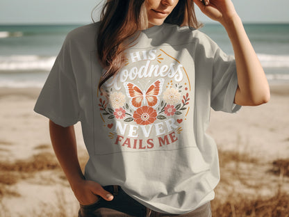 T-shirt with "His Goodness Never Fails Me" text and floral butterfly design.