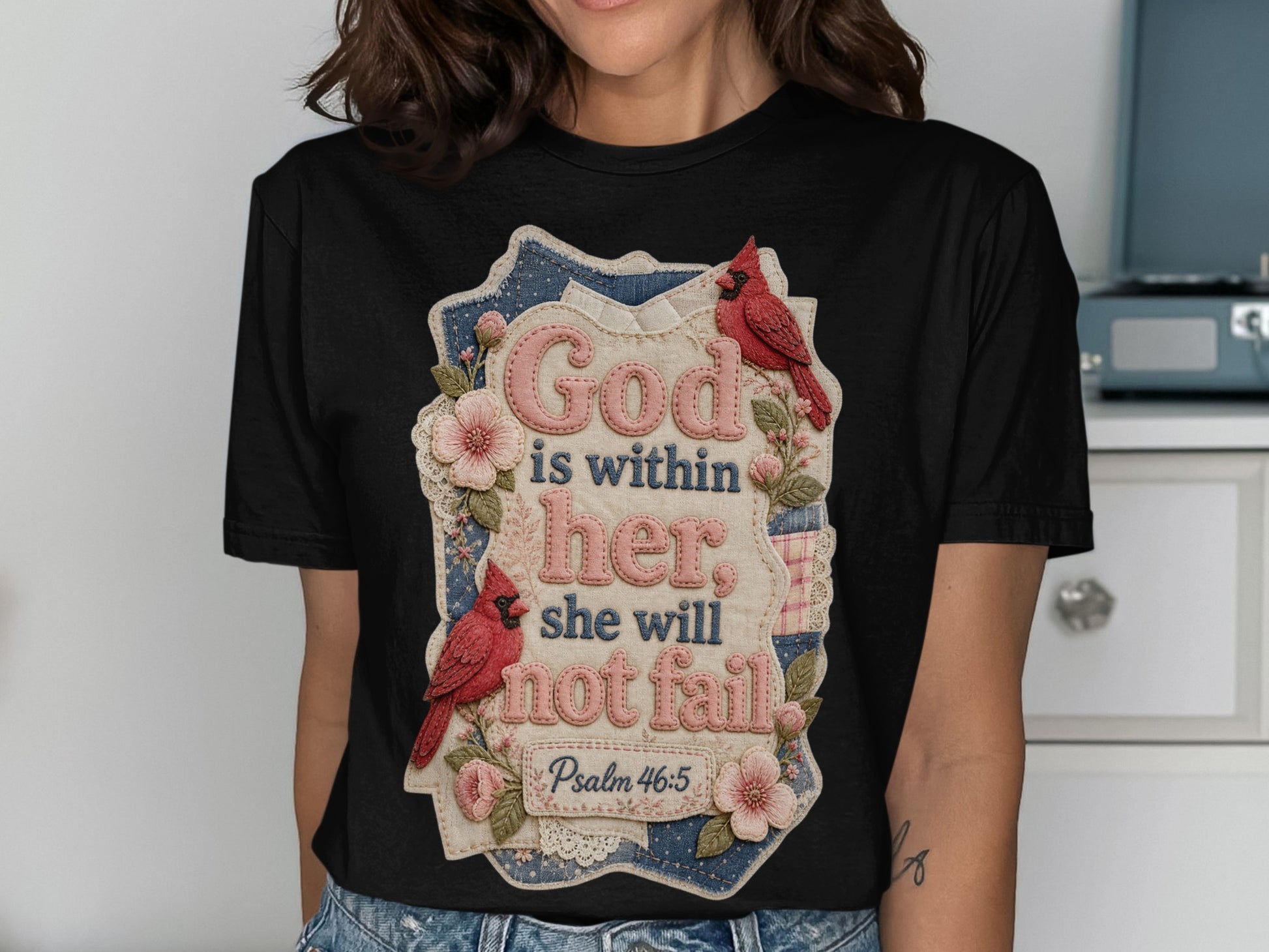 Black t-shirt with floral design and text "God is within her she will not fail Psalm 46:5".