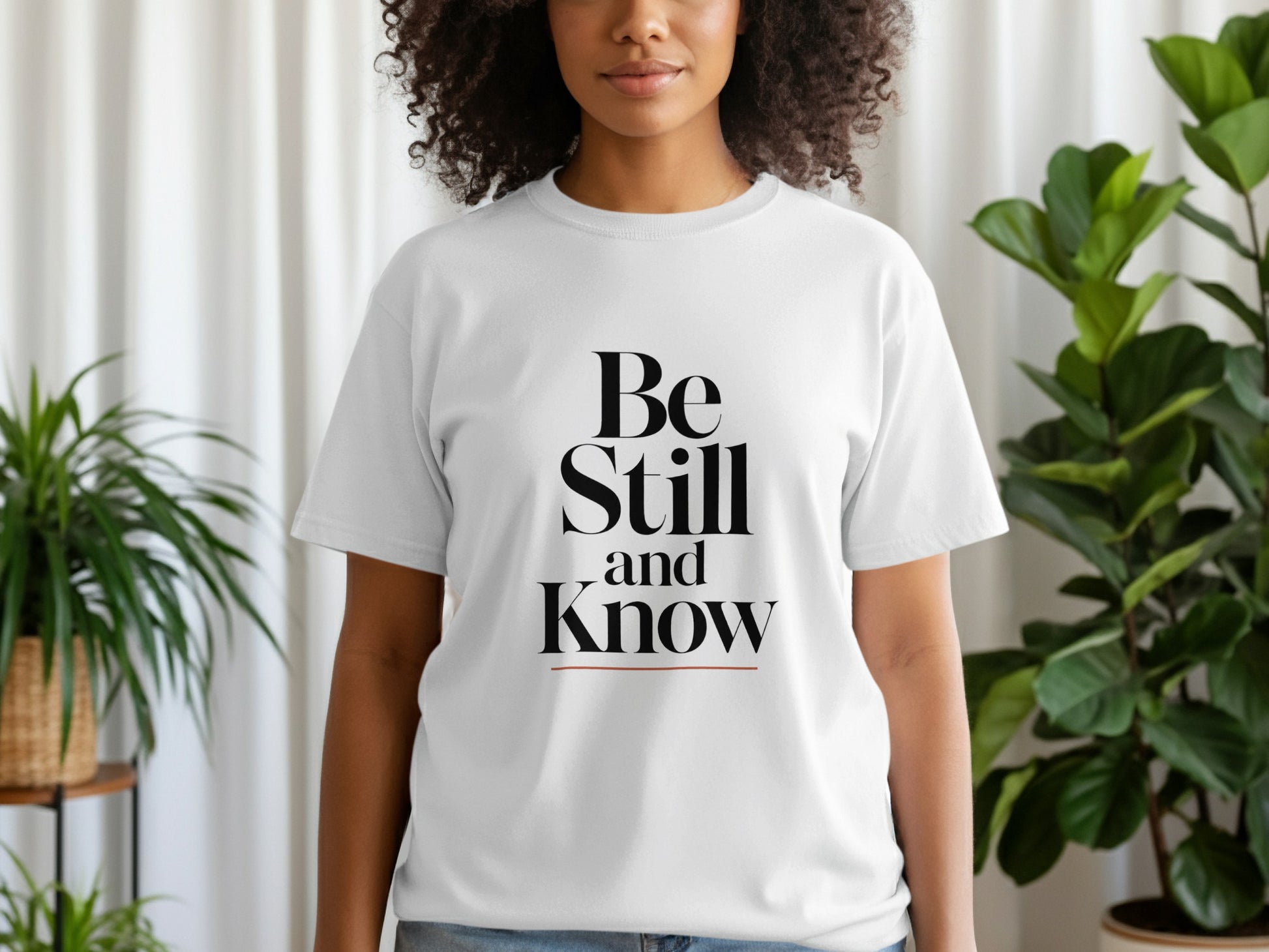 White t-shirt with black text "Be Still and Know".