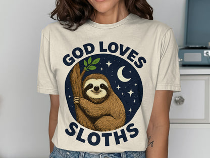 T-shirt graphic: Sloth on tree branch, "God Loves Sloths" text, night sky with moon and stars.