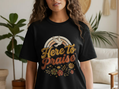 Black t-shirt with "Here to Praise" text, rainbow, dove, and floral design.
