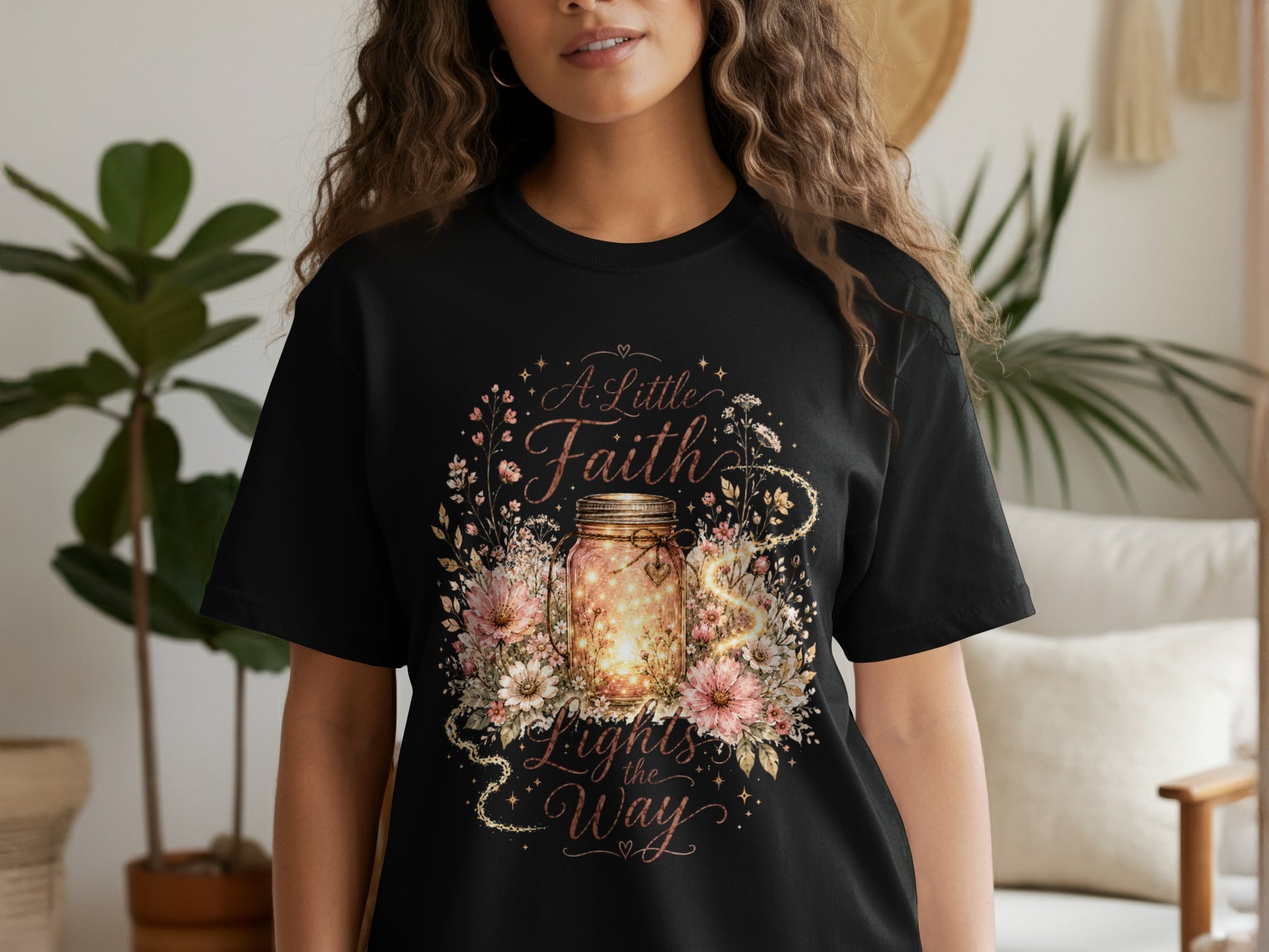 Black t-shirt with floral design and text "A Little Faith Lights the Way".