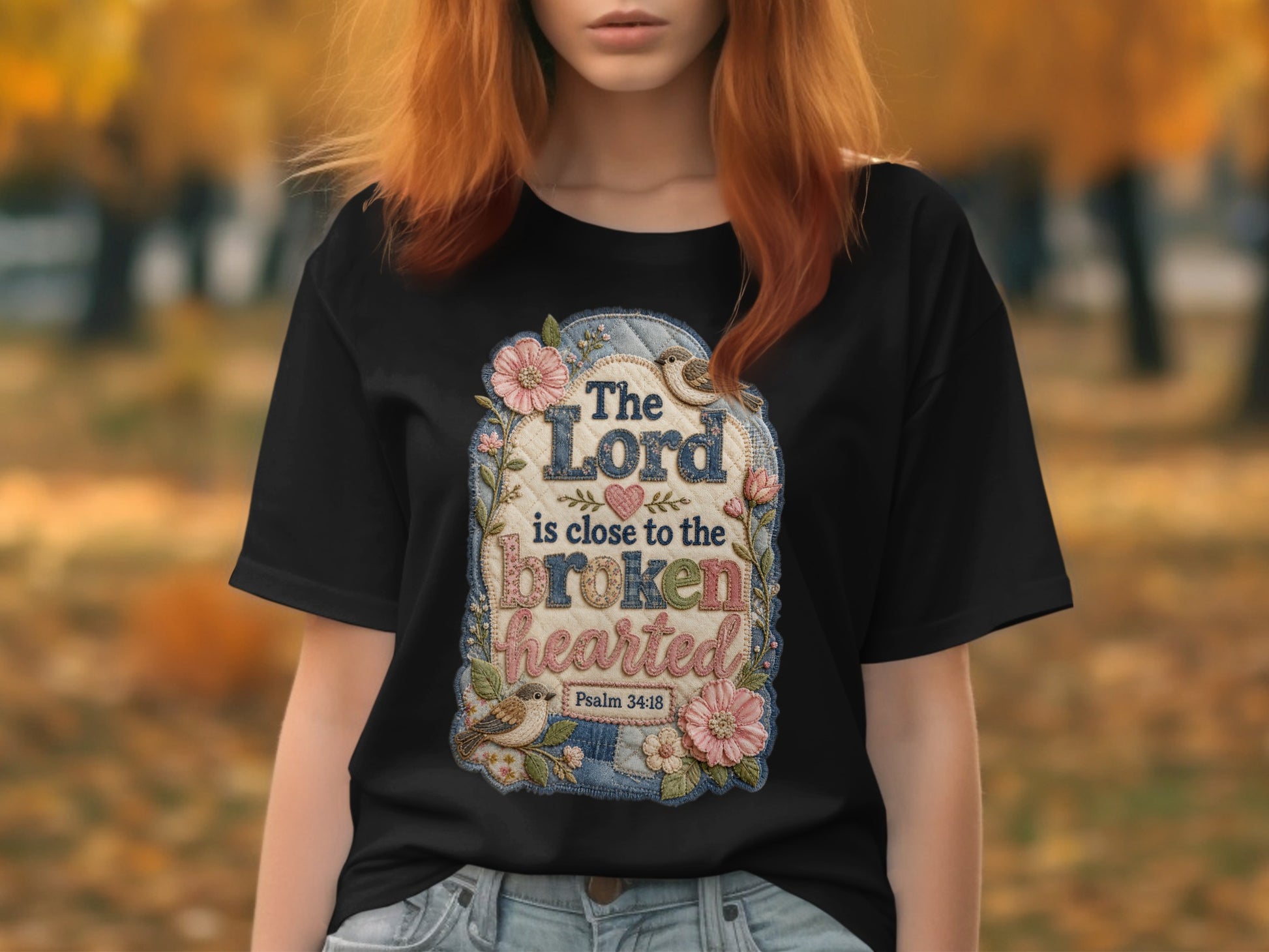 Black t-shirt with floral patch and Bible verse "The Lord is close to the brokenhearted."