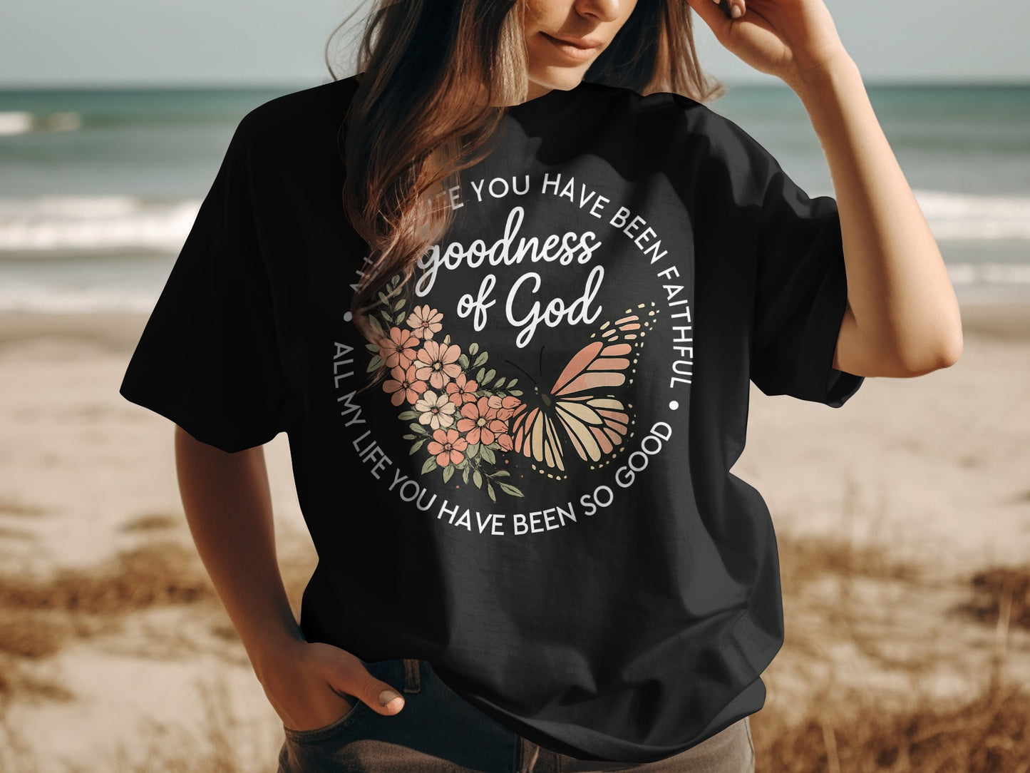 Black t-shirt with butterfly and floral wreath graphic and religious text.