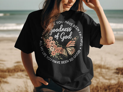 Black t-shirt with butterfly and floral wreath graphic and religious text.