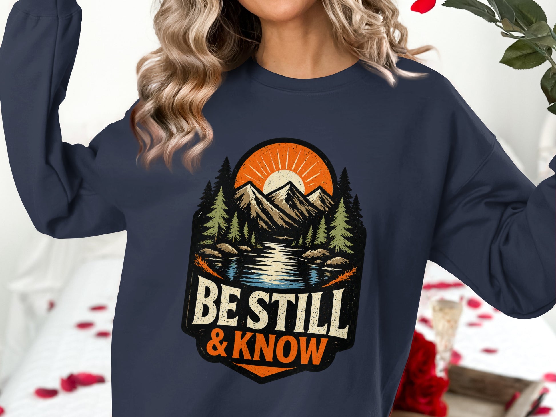 Navy sweatshirt with "Be Still & Know" nature graphic.