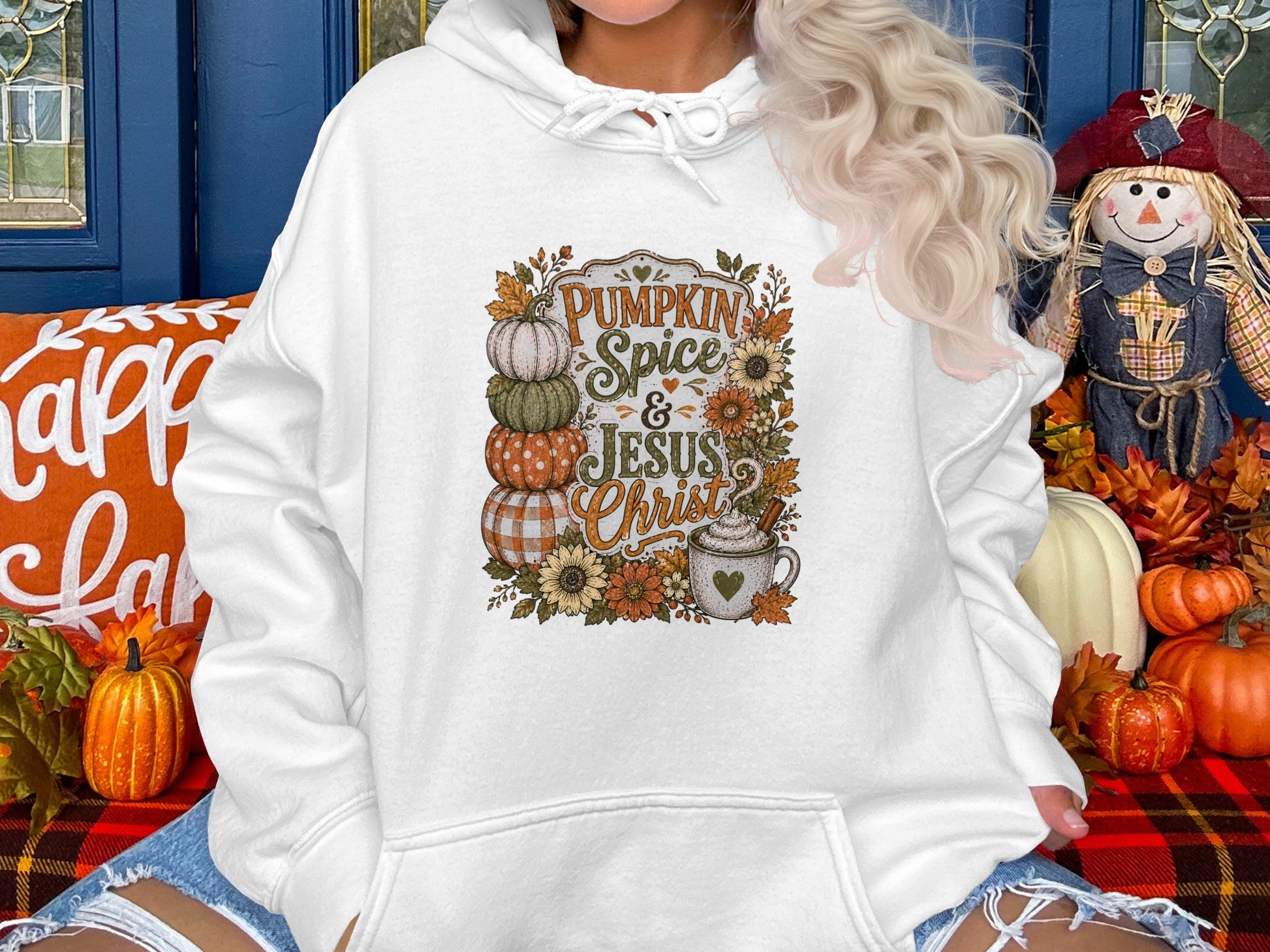 White hoodie with "Pumpkin Spice & Jesus Christ" text, stacked pumpkins, and coffee mug design.