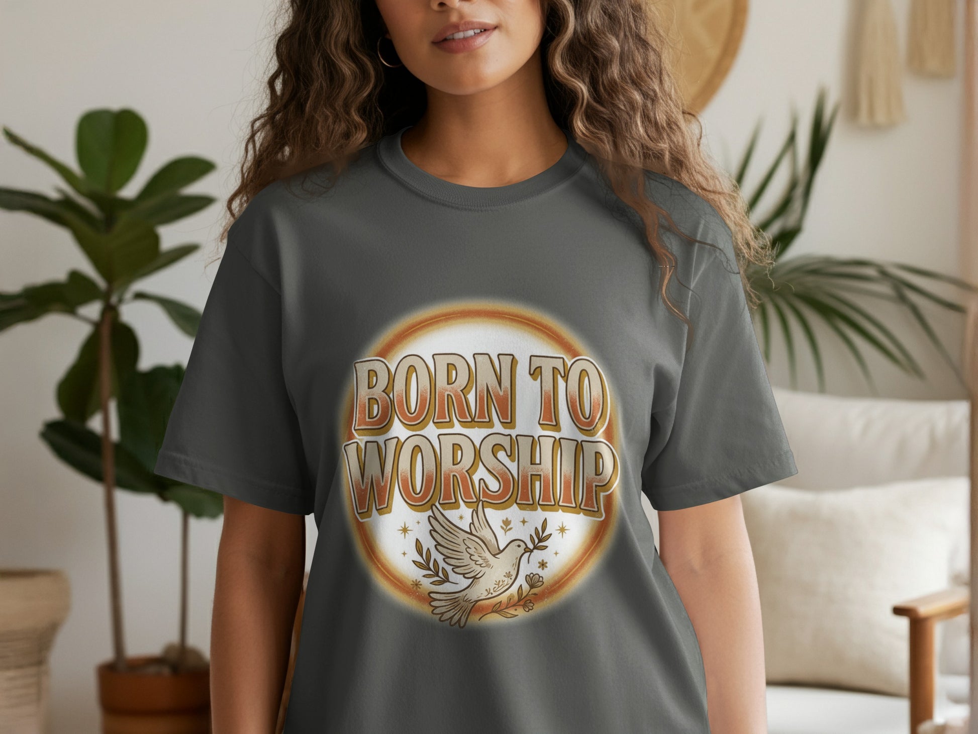 A woman wears a dark grey t-shirt with the text "BORN TO WORSHIP" and a dove.