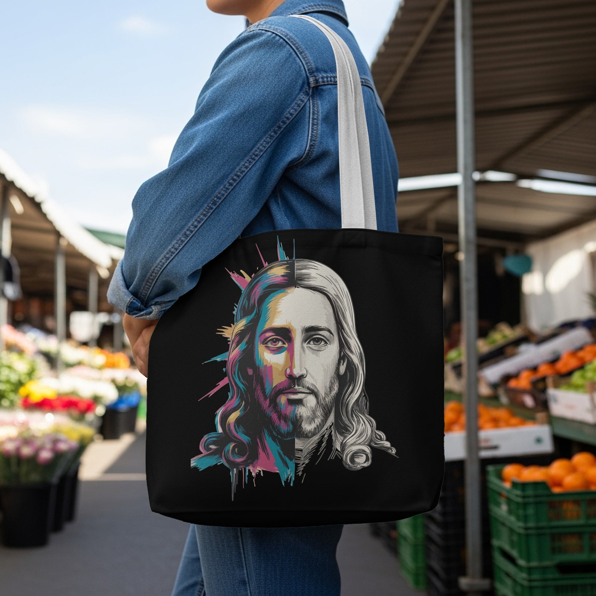 Black tote bag with a split portrait of Jesus, half in vibrant color, half in grayscale.