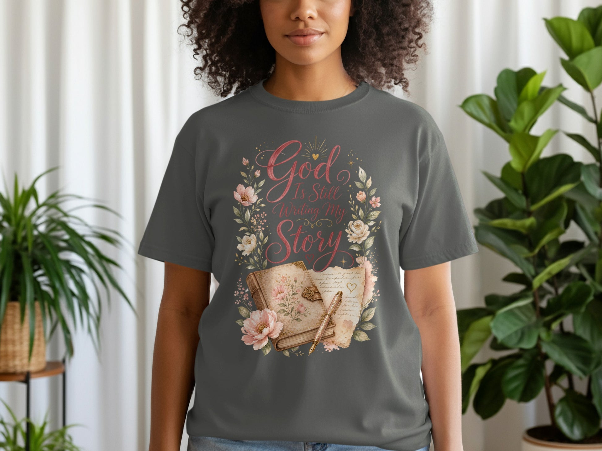 Gray t-shirt with floral wreath graphic and text "God Is Still Writing My Story."