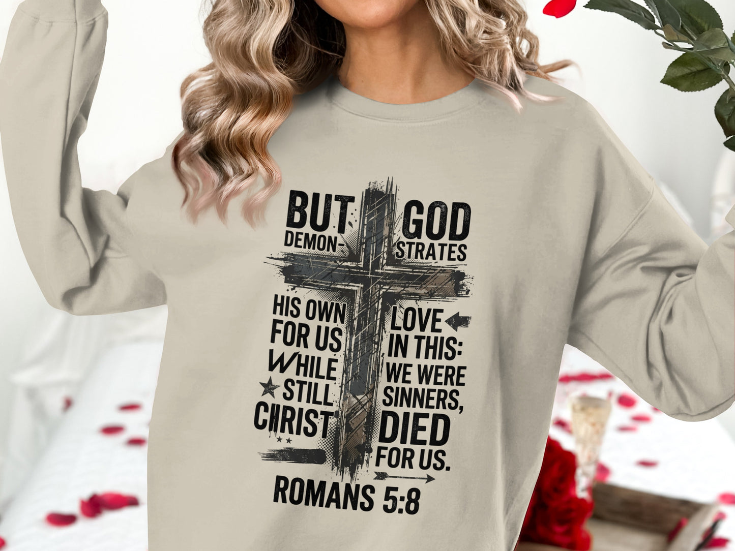 Sweatshirt with "BUT GOD DEMONSTRATES HIS OWN LOVE FOR US WHILE ★STILL WE WERE SINNERS, CHRIST DIED FOR US. ROMANS 5:8" text.