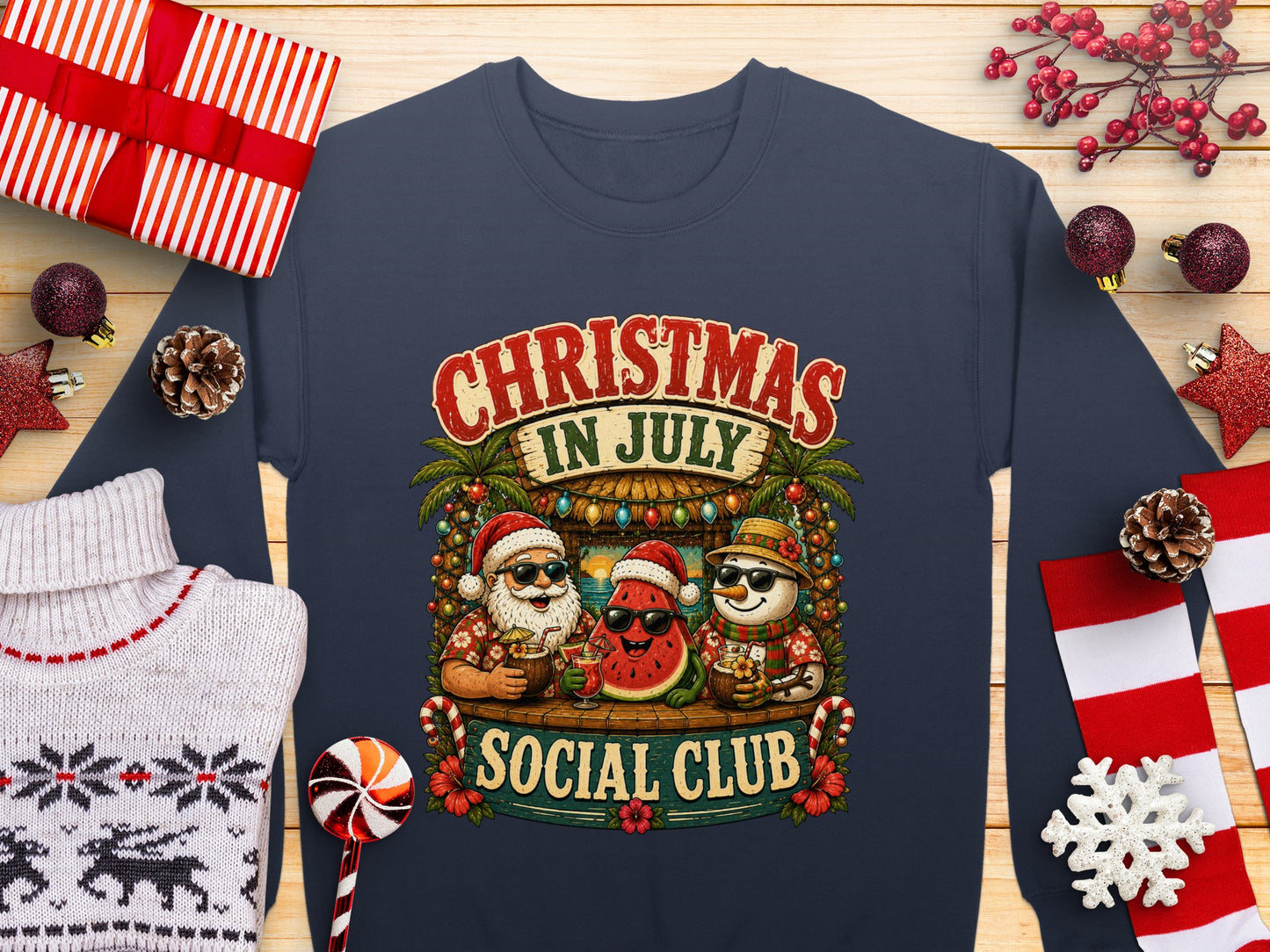 Christmas in July Social Club sweatshirt with festive watermelon and Santa characters.
