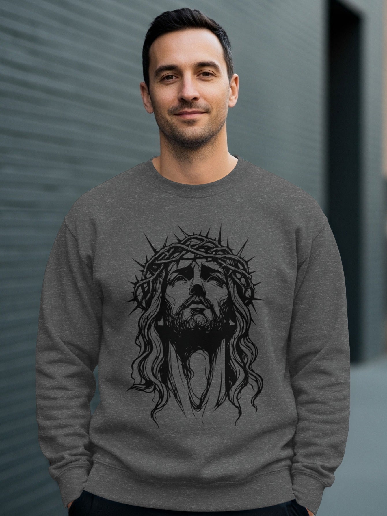 Man wearing a crewneck sweatshirt with a charcoal drawing of Jesus' face.