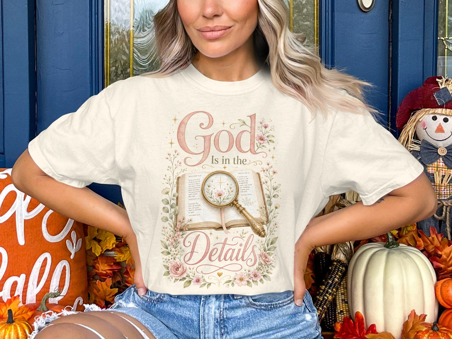 Cream t-shirt with "God Is in the Details" text and floral design over an open book.
