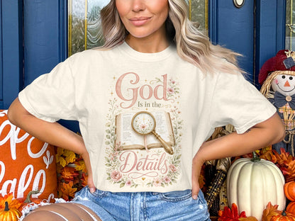 Cream t-shirt with "God Is in the Details" text and floral design over an open book.