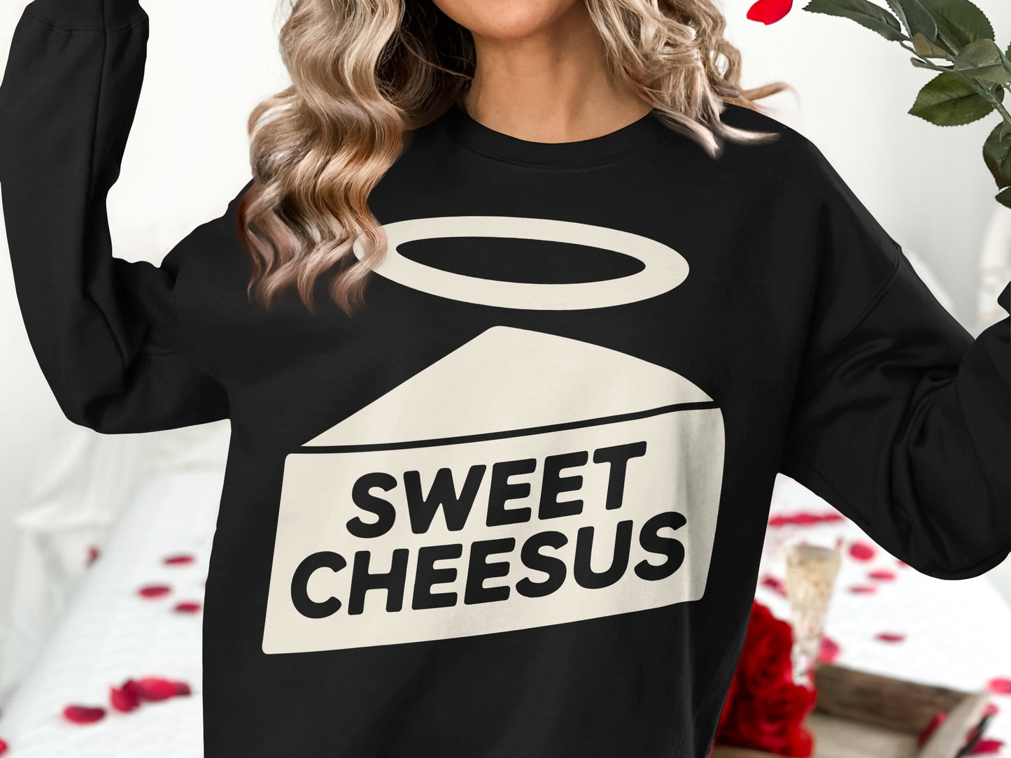 Black sweatshirt with "SWEET CHEESUS" text and halo above cheese slice graphic.