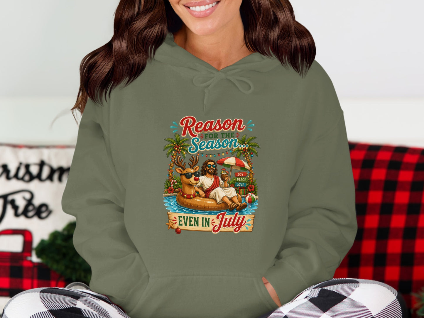 Hoodie with cartoon of a reindeer and Jesus in a pool float with text "Reason for the Season EVEN IN JULY".