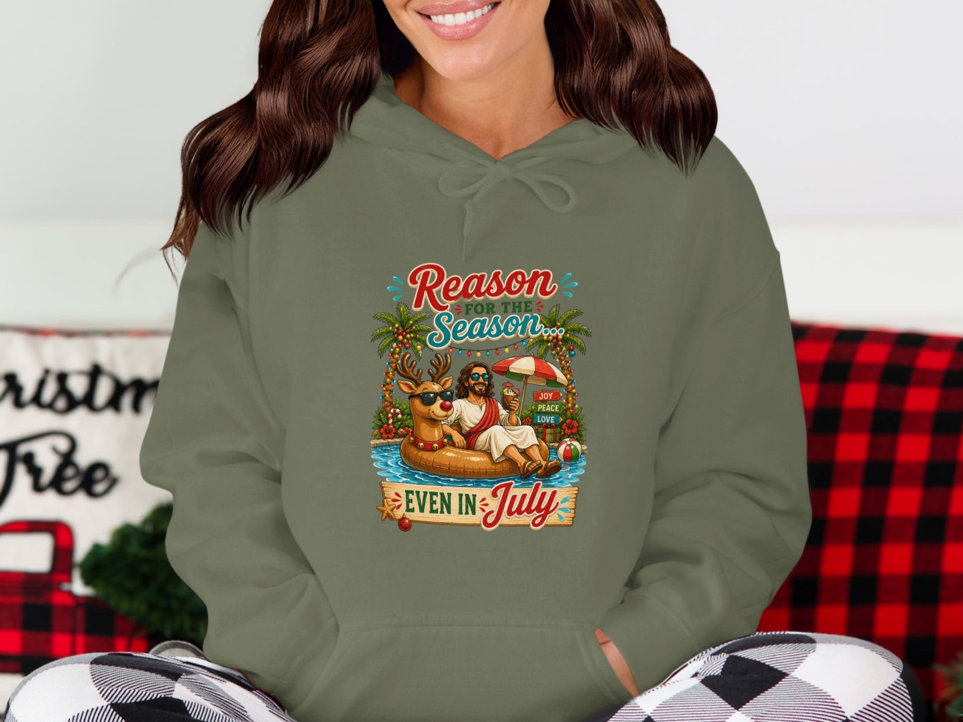 Hoodie with cartoon of a reindeer and Jesus in a pool float with text "Reason for the Season EVEN IN JULY".