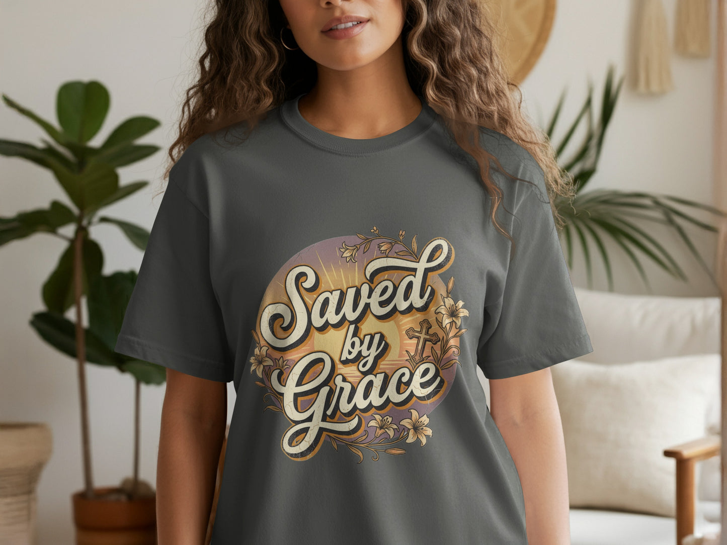 Dark grey t-shirt with "Saved by Grace" text and floral cross graphic.