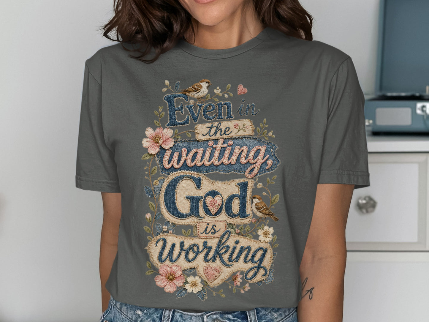 Gray t-shirt with "Even in the waiting God is working" text and floral accents.