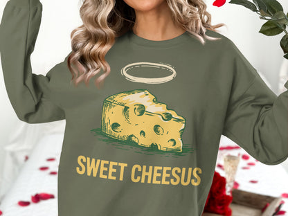 Olive green crewneck sweatshirt with "Sweet Cheesus" text and a halo-adorned cheese wedge graphic.