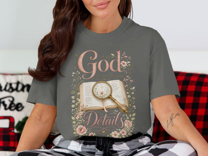 T-shirt with "God is in the Details" text and floral design over open book.