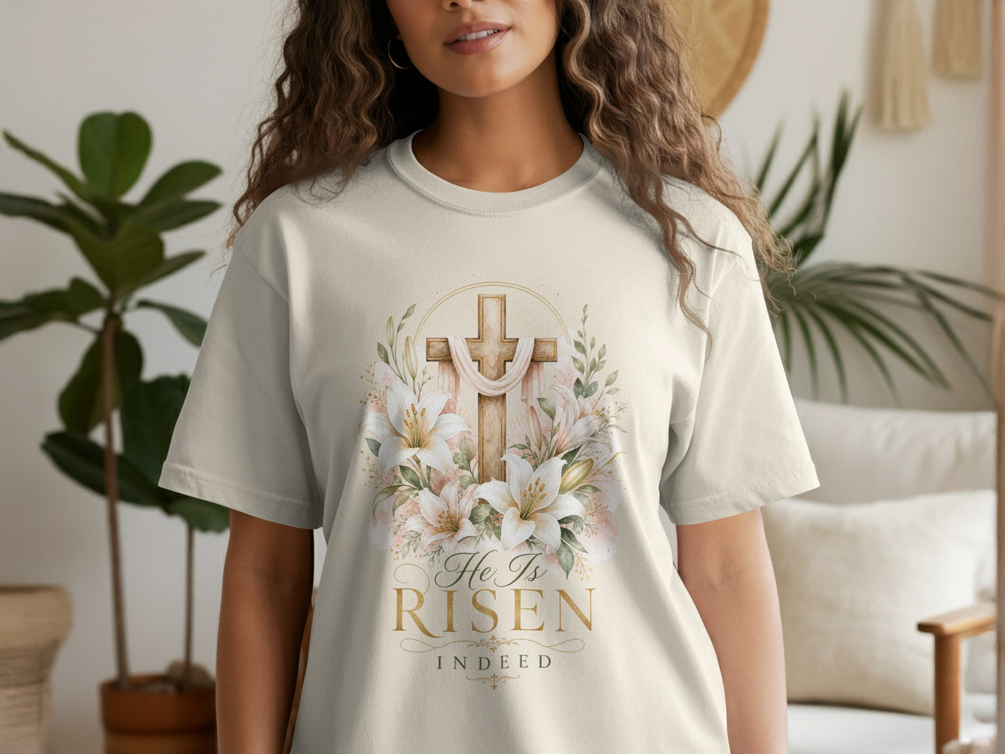 Ecru t-shirt with a watercolor cross, lilies, and text "He Is Risen Indeed."