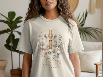 Ecru t-shirt with a watercolor cross, lilies, and text "He Is Risen Indeed."