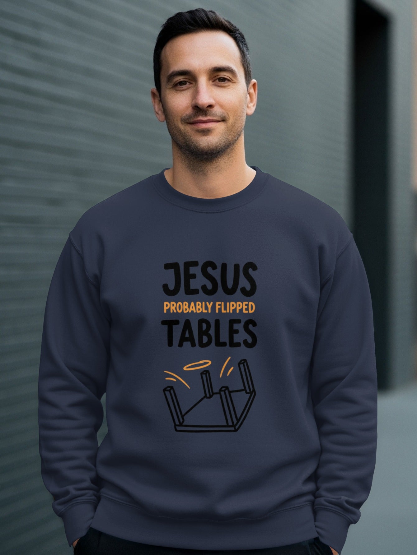 Man wearing a navy sweatshirt with "Jesus Probably Flipped Tables" graphic.