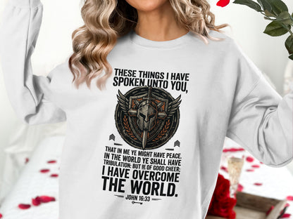 White sweatshirt with shield emblem and John 16:33 Bible verse.