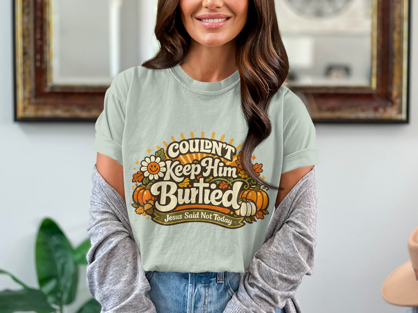 Light blue t-shirt with "Couldn't Keep Him Buried" text and pumpkins.