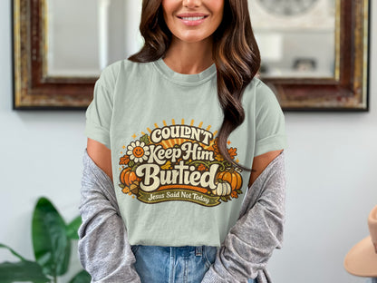 Light blue t-shirt with "Couldn't Keep Him Buried" text and pumpkins.