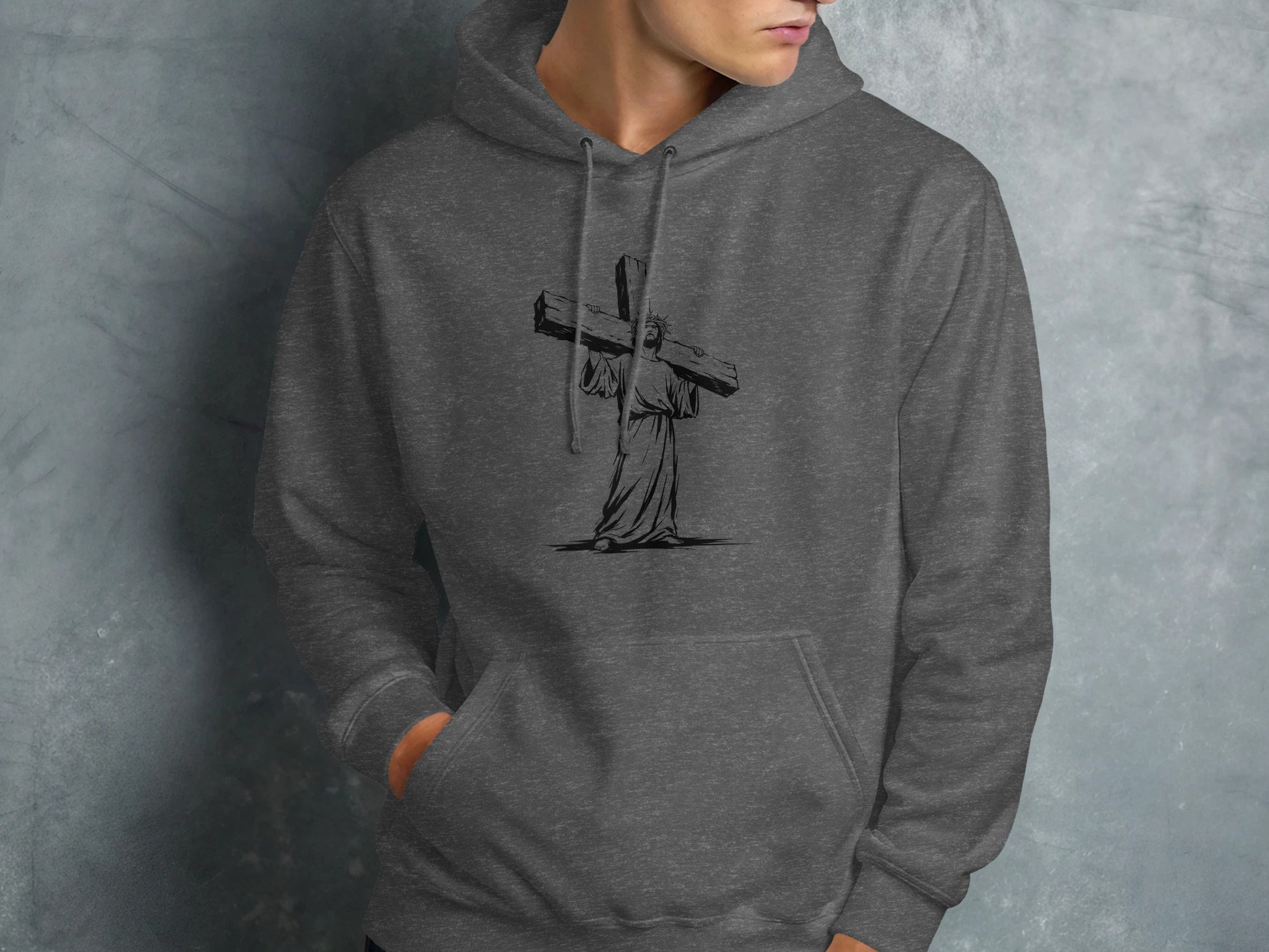 Man in dark grey hoodie with Jesus carrying cross graphic.